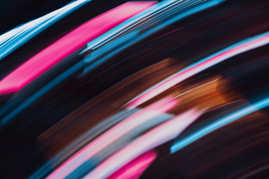 A blurry photo of a black background with pink and blue circles